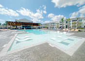 Thumbnail 1 of 23 - A large swimming pool with a building in the background.