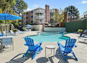 Thumbnail 23 of 33 - a pool with blue chairs and umbrellas next to a resort style swimming pool