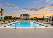 Thumbnail 3 of 25 - A large swimming pool surrounded by lounge chairs and umbrellas.