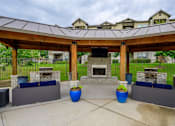 Thumbnail 15 of 18 - a covered patio with a stone fireplace and a pavilion