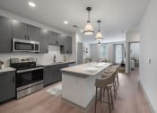 Thumbnail 4 of 21 - an open kitchen and dining area with a large island and a table with chairs