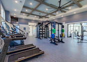 Thumbnail 10 of 40 - A gym with treadmills, weights, and exercise equipment.
