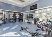 Thumbnail 11 of 40 - A gym with a variety of equipment including a stationary bike and a rowing machine.