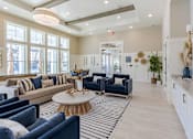 Thumbnail 15 of 40 - A living room with a blue couch and a white coffee table.