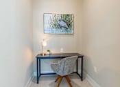 Thumbnail 4 of 40 - A painting of a bird is hanging on the wall above a desk with a chair and a lamp.