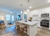 Thumbnail 1 of 40 - A modern kitchen with white cabinets and stainless steel appliances.