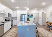 Thumbnail 2 of 40 - A kitchen with a blue island in the middle.