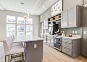 Thumbnail 5 of 51 - A kitchen with a white counter top and a white chair.