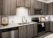 Thumbnail 11 of 27 - our apartments have a modern kitchen with stainless steel appliances and granite counter tops