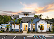 Thumbnail 2 of 27 - a blue and white house with a sunset behind it