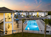 Thumbnail 15 of 27 - Ridgeville, SC, Luxury Apartments with In-Unit Washer and Dryer - Preserve at Ridgeville - Outdoor Swimming Pool With Lounge Chairs, Palm Trees, And Poolside Seating.