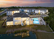 Thumbnail 26 of 27 - an aerial view of a building with a pool at dusk