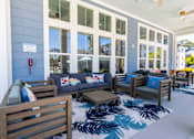 Thumbnail 26 of 40 - A blue building with a sign on it and a blue rug with palm tree designs in front of it.