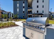 Thumbnail 23 of 40 - A silver grill is in the foreground of a residential area.