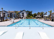 Thumbnail 34 of 40 - A large swimming pool in front of apartment buildings.