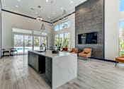 Thumbnail 6 of 31 - A modern kitchen with a large island and a refrigerator on the left.