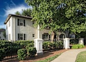 Thumbnail 17 of 18 - an apartment building with a sidewalk and trees in front of it at Avondale Station Apartments, Georgia