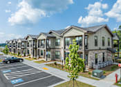 Thumbnail 46 of 50 - a row of townhouses with a car parked in a parking lot