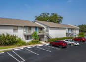 Thumbnail 18 of 34 - a white house with cars parked in a parking lot at L'Estancia, Sarasota, FL, 34231