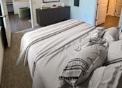 Thumbnail 29 of 50 - A bedroom with a bed in the center and a ceiling fan above it.
