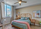 Thumbnail 20 of 35 - A bedroom with a bed, a chair, and a ceiling fan.