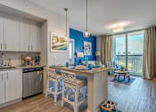Thumbnail 15 of 35 - A kitchen with white cabinets and a blue accent wall.
