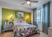 Thumbnail 22 of 35 - A bedroom with a bed, nightstand, and a painting on the wall.