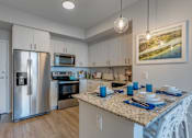 Thumbnail 17 of 35 - A kitchen with a granite countertop and stainless steel appliances.