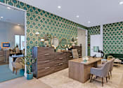 Thumbnail 3 of 35 - a living room with green wallpaper and a desk with chairs