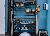 Thumbnail 7 of 35 - a shelf with spheres and helmets on it against a blue wall