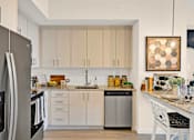 Thumbnail 16 of 35 - a kitchen with white cabinets and stainless steel appliances and a counter top