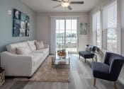 Thumbnail 3 of 27 - a living room with a ceiling fan and a sliding glass door