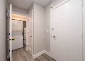 Thumbnail 15 of 48 - A white door is open to a small kitchen with a refrigerator and a microwave.