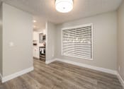 Thumbnail 19 of 48 - A room with a window covered by white blinds and wooden flooring.