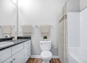 Thumbnail 8 of 29 - A white toilet in a bathroom with a white shower curtain.