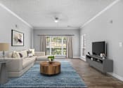 Thumbnail 5 of 29 - A living room with a grey couch, a wooden coffee table, and a flat screen TV.