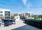 Thumbnail 37 of 49 - 2-Bedroom Luxury Apartments in Decatur, GA - Reserve Decatur - Rooftop Entertainment Lounge with Tables and Chairs, Couch, Cafe Lights, and Expansive Views.