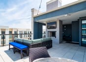 Thumbnail 39 of 49 - a rooftop patio with a fireplace and a blue table and chairs