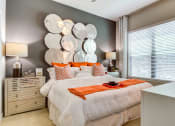 Thumbnail 22 of 49 - a bedroom with a white bed and orange pillows
