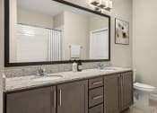 Thumbnail 32 of 49 - a bathroom with a large mirror and a sink and a toilet