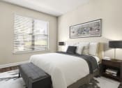 Thumbnail 29 of 49 - Upscale Apartments in Decatur, GA - Reserve Decatur - Bedroom with Designer Plank Flooring, Area Rug, Full-Size Bed, Nightstands with Lamps, Wall Art, and Large Window with Blinds.