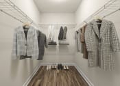 Thumbnail 34 of 49 - a walk in closet with coats and jackets and wooden floors