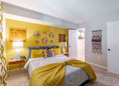 Thumbnail 20 of 25 - A bedroom with a bed covered in a yellow blanket.