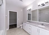 Thumbnail 31 of 49 - A bathroom with a white toilet, sink, and mirror.