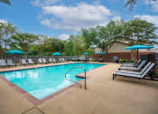 Thumbnail 22 of 28 - our resort style swimming pool is surrounded by lounge chairs and umbrellas