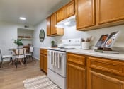 Thumbnail 2 of 28 - an open kitchen with wooden cabinets and a dining room with a table and chairs