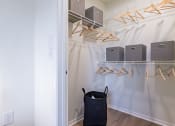 Thumbnail 12 of 28 - a walk in closet with a basket and shelves