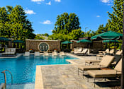 Thumbnail 1 of 40 - A pool area with sun loungers and umbrellas.