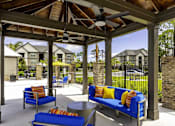 Thumbnail 18 of 32 - A patio with blue couches and a ceiling fan.