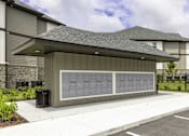 Thumbnail 28 of 32 - A modern building with a grey roof and a long grey panel on the side.